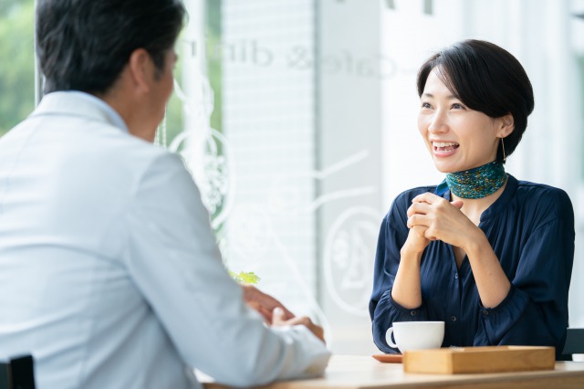 男性と笑顔で会話するミドル女性