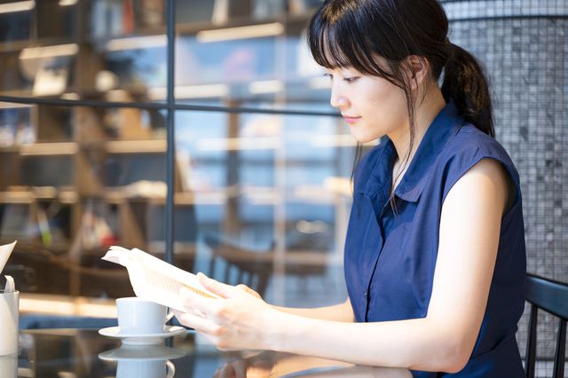 カフェで読書する30代後半女性